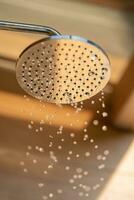 acérquese al cabezal de la ducha al aire libre para bañarse y ducharse con agua fría antes de tirarse a la piscina del complejo. foto