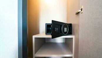 Opened Unlock digital modern Black Safe box, Stroungbox on the shelf in wood Closet in Hotel room photo