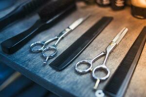 peines y tijeras para corte pelo mentira en un estante en un peluquería salón foto