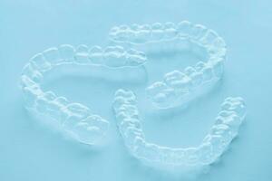 Invisible aligner teeth retainers on a blue background photo