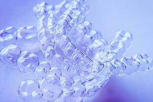 Invisible aligner teeth retainers on a blue background photo