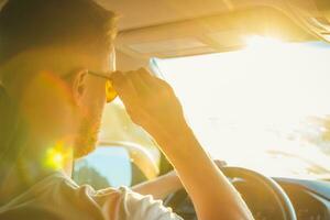 un hombre se sienta detrás el rueda de su coche en un soleado día foto