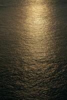 Close up to the texture of the sea surface with the abstract golden colour background in the twilight time. photo