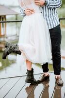 piernas de el recién casados en el antecedentes de el muelle.el novia y novio estar y actitud en Zapatos en el muelle. foto