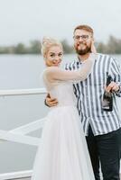 Beautiful just married hugging on the pier by the water. photo