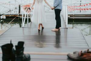 pies de el recién casados en el antecedentes de el muelle.el novia y novio Vamos descalzo a lo largo el muelle. foto