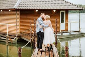 The beautiful newlyweds tenderly kissing and embracing on the pier. photo