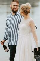 Beautiful just married walk along the coastline and hold hands. photo