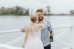 joven recién casados abrazando en el muelle por el agua. foto