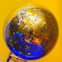 Big disco ball on a colored background in a nightclub photo