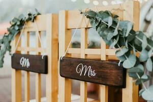 Chairs for bride and groom decorated with flowers with signs mr and mrs for wedding ceremony photo