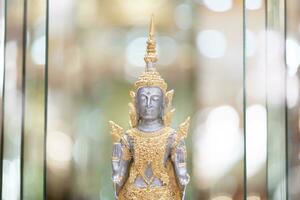 Deity statue standing straight made of silver, wearing silver gold costume with Chada on top of his head. Surrounded by sparkleling decoration. photo