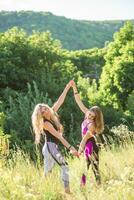 Woman yoga instructor teaching beginner in nature on a sunny day photo