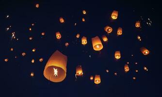 Release the traditional paper lanterns into the sky during the night of the festival in Thailand. photo