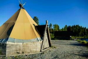 a teepee is set up on the side of a gravel road photo