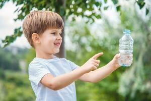 frio bebé bebidas limpiar agua desde un botella en un soleado día en naturaleza foto