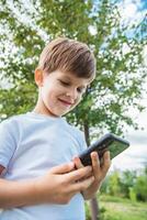 the child speaks on the phone in nature photo