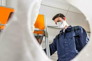 A worker stands at the machine in a factory for the manufacture of medical masks with nanofiber. Coronovirus and Covid-19 Protection photo