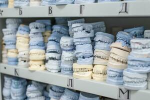 Warehouse of plaster models of human jaws in an orthodontic clinic. Control and diagnostic dental casts for aligners. photo