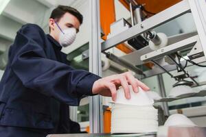 A worker stands at the machine in a factory for the manufacture of medical masks with nanofiber. Coronovirus and Covid-19 Protection photo