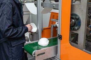 A worker stands at the machine in a factory for the manufacture of medical masks with nanofiber. Coronovirus and Covid-19 Protection photo