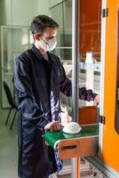 A man works at a machine for the manufacture of medical masks with nanofiber. Coronovirus and Covid-19 Prevention photo