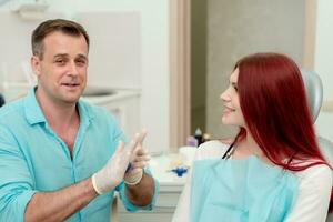 The orthodontist crumples the silicone material for the impression tray that will be placed in the patient's mouth to shape her teeth photo