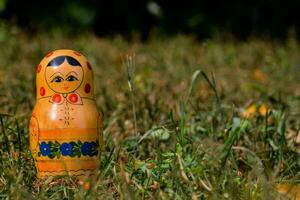 a russian doll sitting in the grass photo