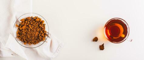 Healing tea from wild birch chaga mushroom in a cup on the table top view web banner photo