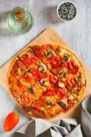 americano S t. Luis estilo Pizza con tocino, hongos y Tomates en un tablero parte superior y vertical ver foto