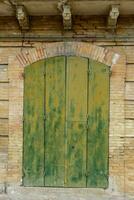 antiguo verde puertas en un ladrillo edificio foto