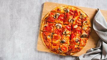 American St. Louis Style pizza with bacon, mushrooms and tomatoes on a board top view web banner photo