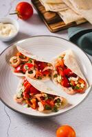 Soft appetizer mini tacos with shrimp, tomatoes and herbs on a plate vertical view photo