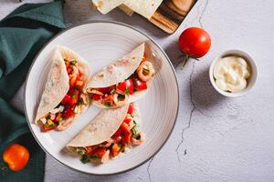 Vegetarian mini tacos with tomatoes, shrimp and herbs on a plate on the table top view photo