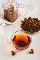 Healing tea from wild birch chaga mushroom in a cup on the table vertical view photo