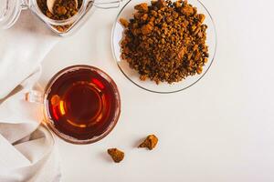 Chaga therapeutic tea from birch mushroom in a cup on the table top view photo