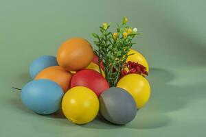 Colorful eggs, symbolizing Easter, on a colorful background and flowers photo