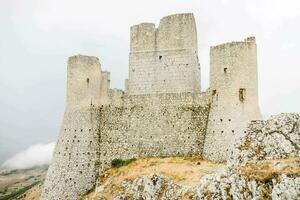 an old white castle on a cliff photo