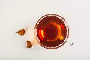 Close up of chaga therapeutic tea from birch mushroom in a cup on the table top view photo