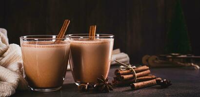 Chocolate Christmas eggnog with spices in glasses on the table web banner photo