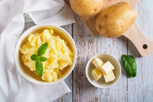 Fresh mashed potatoes and basil leaves in a bowl on the table top view photo