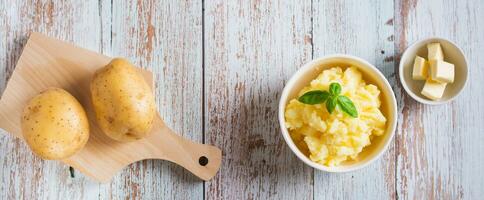 Bowl with delicious homemade mashed potatoes and basil on the table top view web banner photo