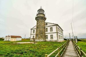 the lighthouse is located on a hill with a wooden walkway photo