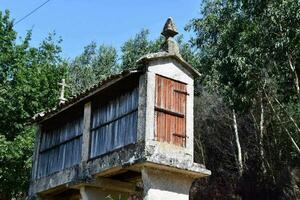 un pequeño Roca y madera edificio con un cruzar en parte superior foto