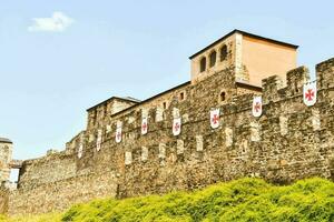 the castle walls are made of stone and have flags on them photo