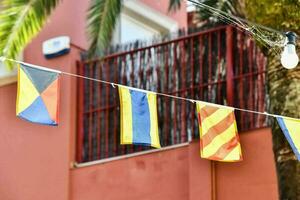 several colorful flags are hanging from a string photo