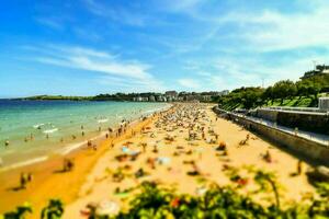 a beach with many people on it and a blue sky photo