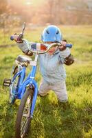 Cute child is driving a bike on a sunny day at sunset photo