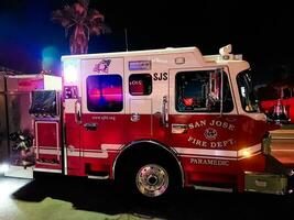 San Jose, California, USA - 09.02.2023 Fire truck with flashing lights at night, called to a fire alarm in the city. photo