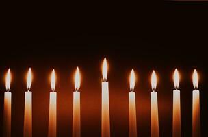 Hanukkah candles. Traditional candelabrum with burning candles on black background. Celebrating religious Jewish holiday. photo